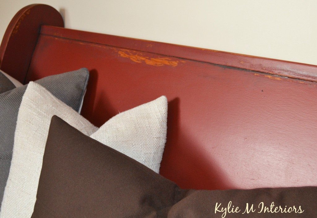 close up of painted wood church pew with red paint in Behr ultra. This photo shows the distressed details