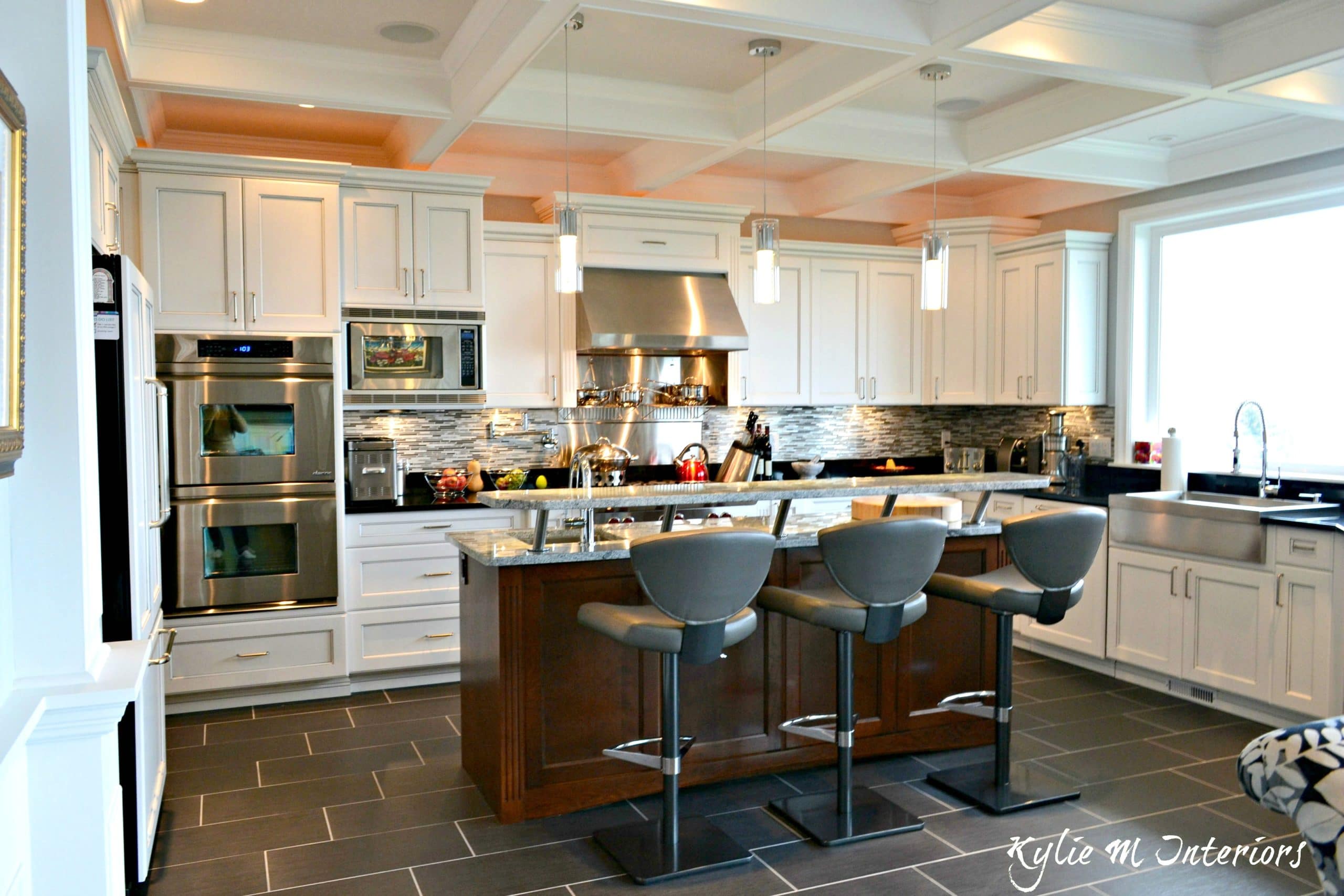 White kitchen with glazed cabinets, dark porcelain tile floor stainless ...
