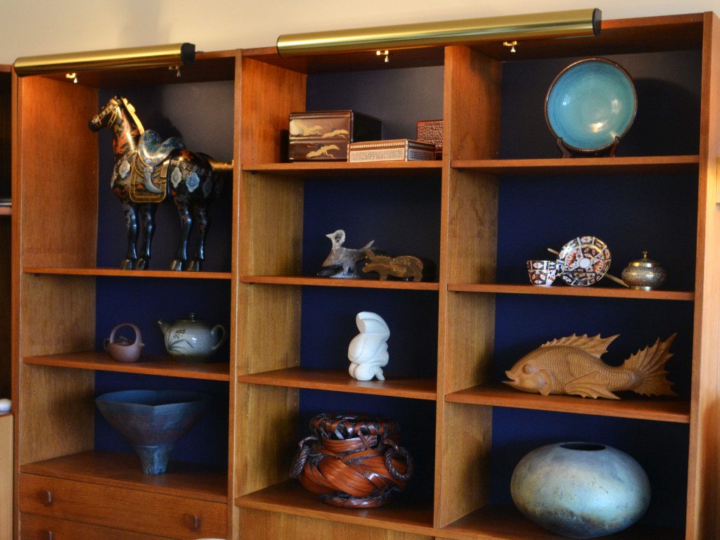 teak bookshelf with painted blue backdrop with accessories