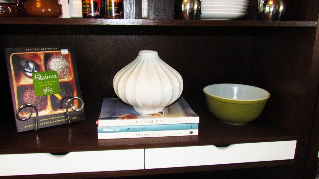 accessorizing a shelf using stacked books and a vase