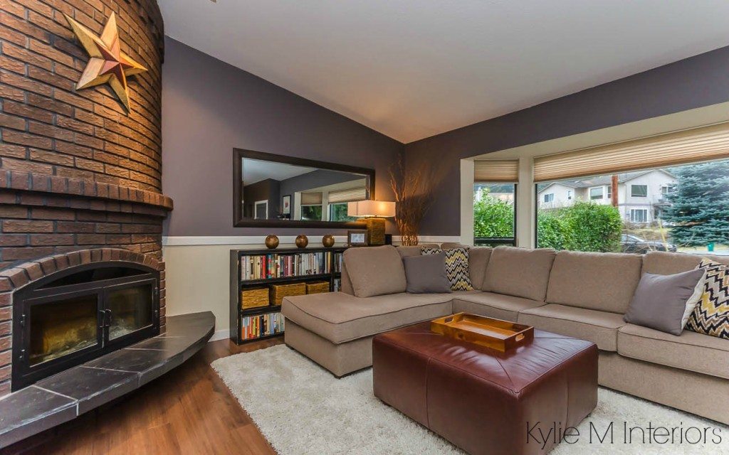 The best purple paint colour by Benjamin Moore, Wet Concrete. Shown in living room wtih brick corner fireplace, chair rail and sectional. Room has been through Home Staging by Kylie M Interiors