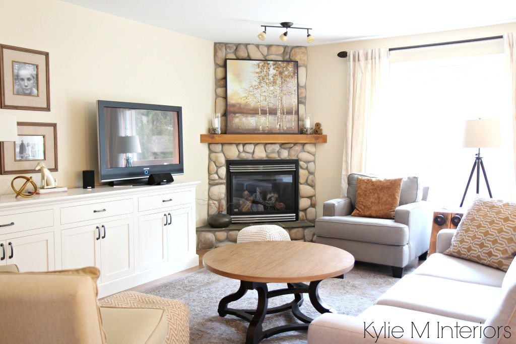 Best paint colour for a warm, south facing room with southern exposure is Benjamin Moore Gentle Cream by Kylie M Interiors. Shown in living room with stone corner fireplace