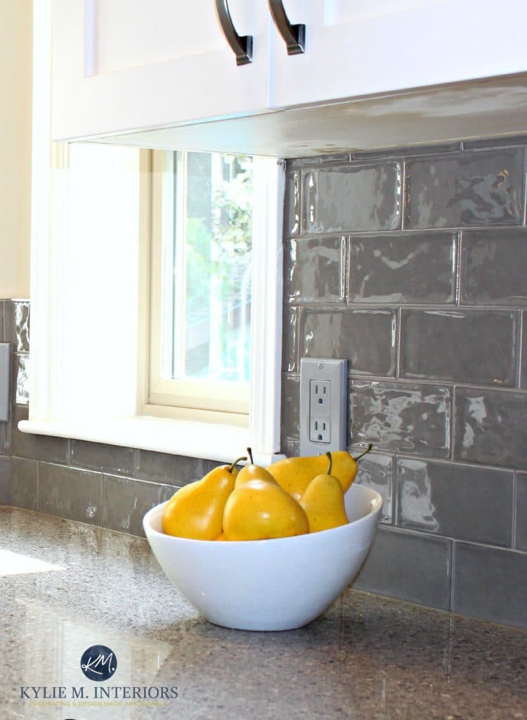 Glazed shiny gray subway tile in kitchen remodel with quartz countertops and white painted cabinets by Kylie M Interiors