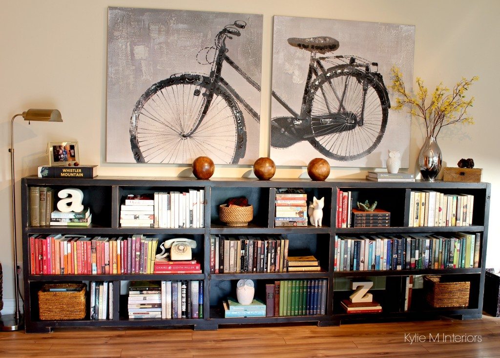 Ideas to personalize a home with home decor and books on a long, low bookcase. Arrange books by colour. Oversized bike canvas artwork