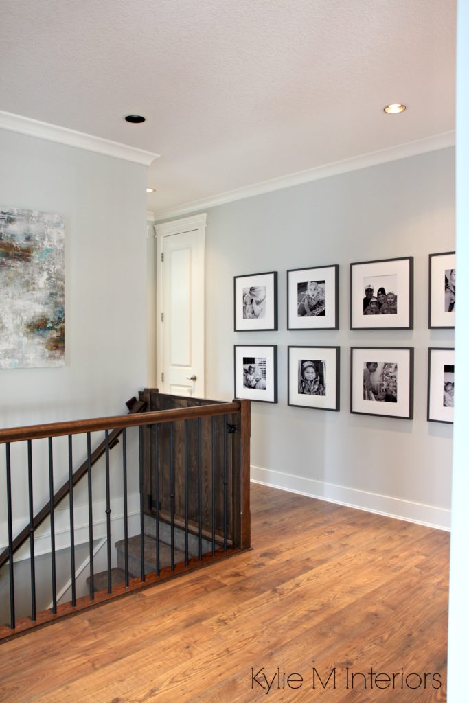 Benjamin Moore Gray Owl one of the best gray paint colours for a dark hallway or staircase by Kylie M Interiors. With photo gallery wall of kids and dark wood and metal stair railing. Kylie M Interiors e-design