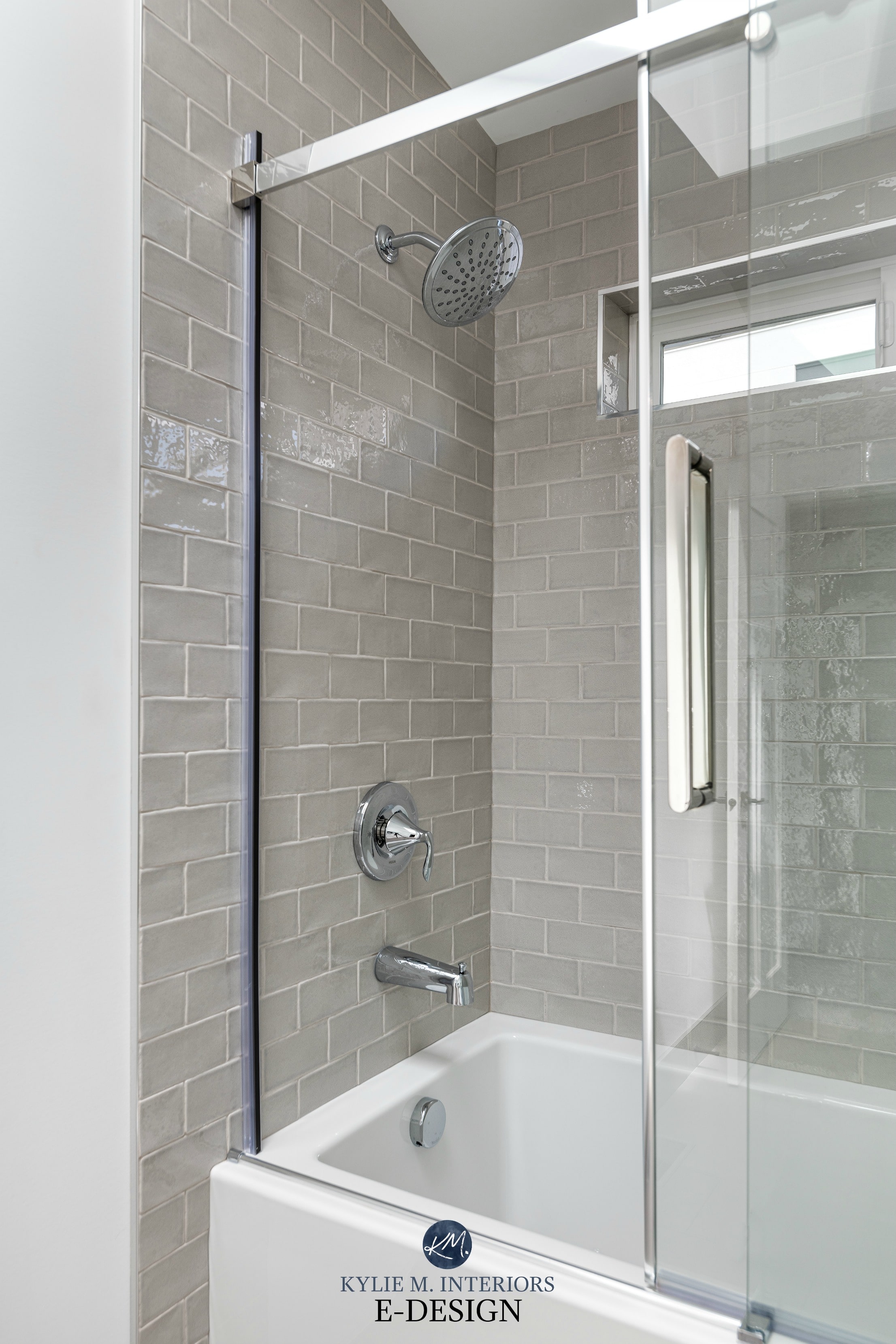 Bathroom, warm gray greige subway tile surround, light gray grout. Tub and shower with glass sliding door. Kylie M Interiors, E-design online paint colour consulting blog