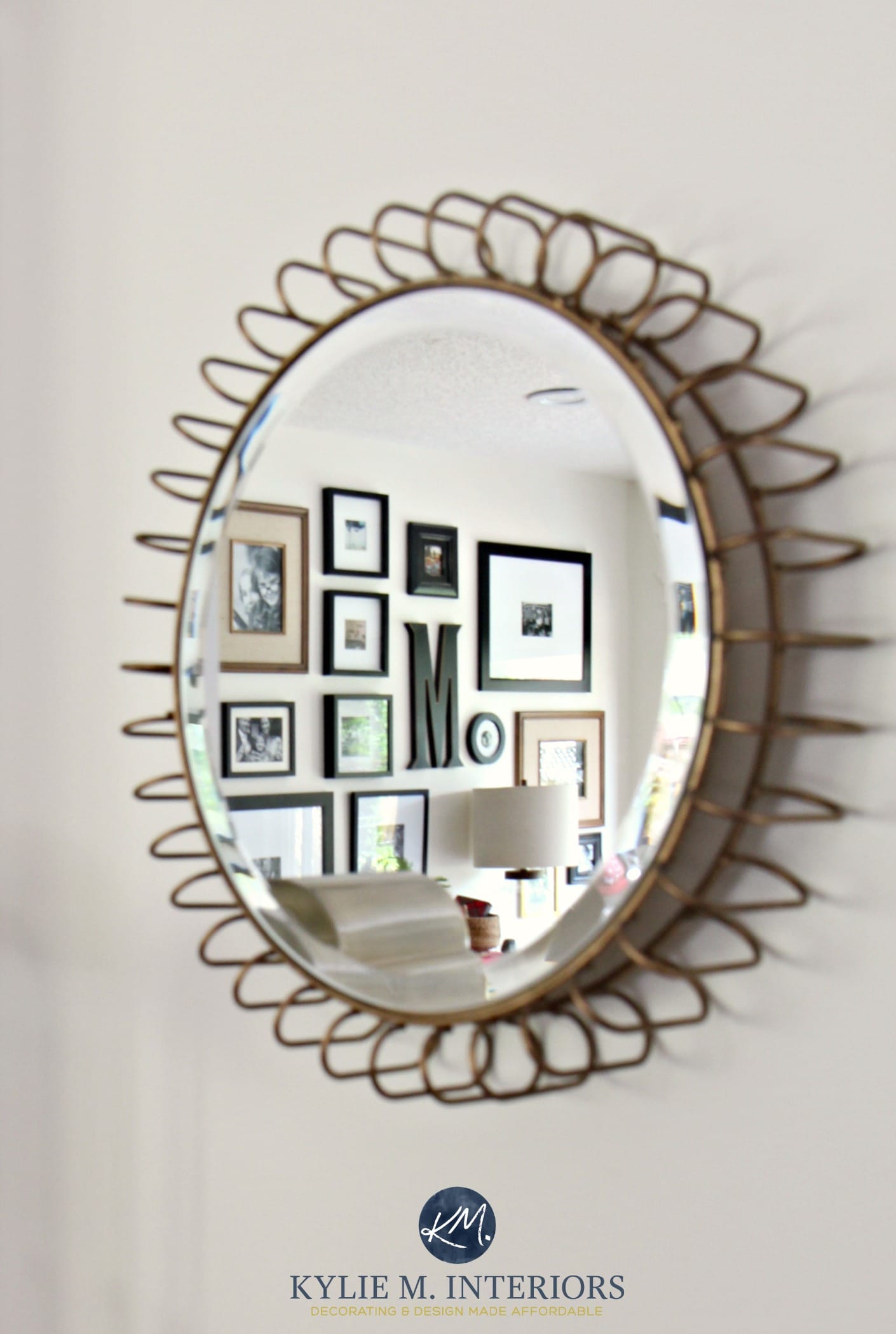 Round accent mirror with gold detail reflecting photo gallery wall on Sherwin Williams Creamy. Kylie M Interiors E-decor and E-design. Color expert