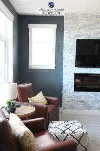 Benjamin Moore Anchor Gray, White Dove trim, travertine stacked stone fireplace, tobacco brown leather chairs, gray carpet. Kylie M Interiors E-design, online paint color consulting. Best blue paint