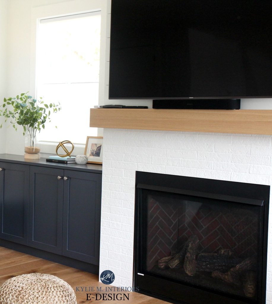 Kylie M Interiors Edesign, online paint colour consulting. Gas fireplace with painted white fake brick, shiplap and wood mantel, Cyberspace navy blue built in cabinets