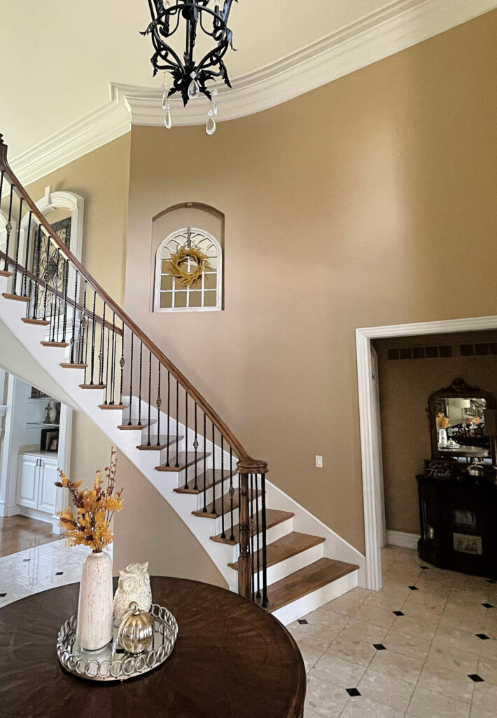 SHERWIN WILLIAMS LATTE, BEST BEIGE TAN PAINT COLOR, TRAVERTINE COLORS IN TILE, DARK WOOD STAIRCASE, WROUGHT IRON,