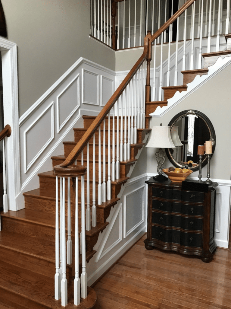 Benjamin Moore Revere Pewter, staircase with red toned oak flooring, white and wood railing, wainscoting. Kylie M Interiors Edesign, online consulting blogger