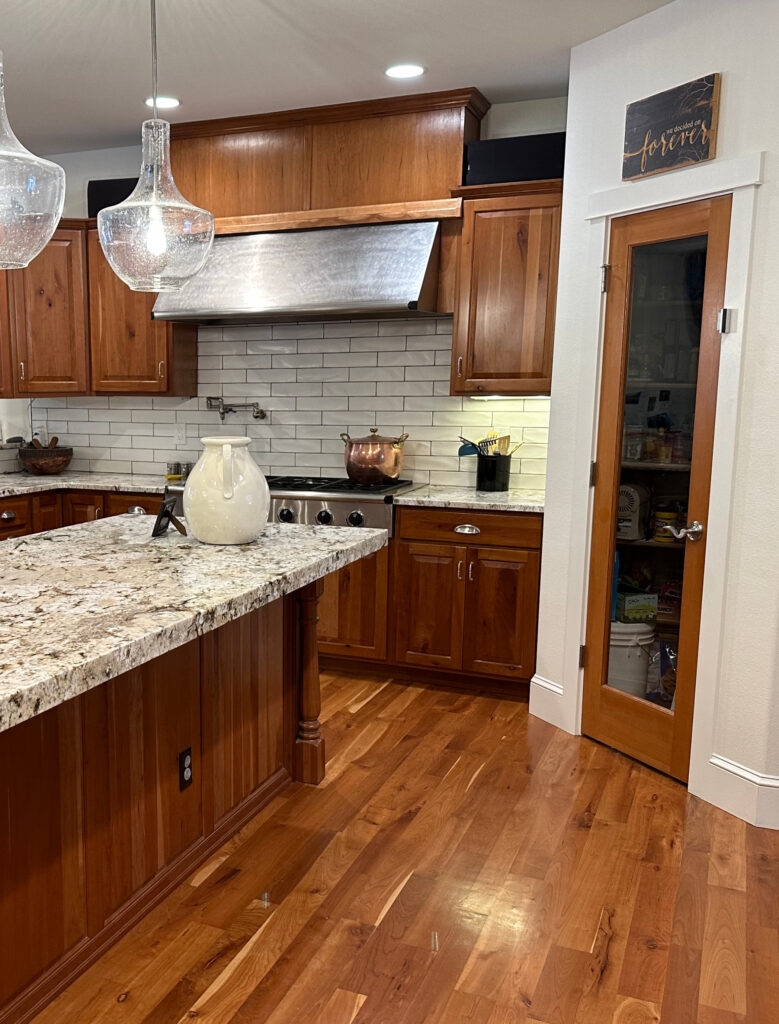 Update kitchen with wood cabinets, wood floor, cherry or red, orange stain. Granite countertops, off-white subway tile backsplash, Creamy walls, Alabaster trim.