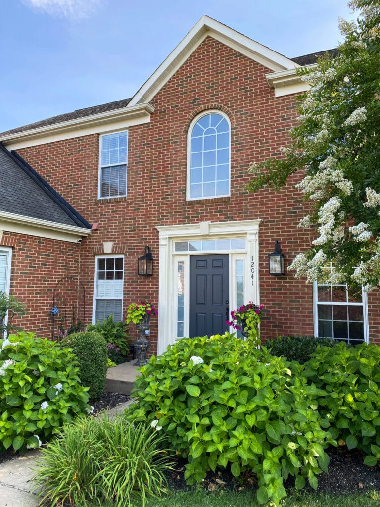 Exterior red brick, no shutters, off white cream trim, Benjamin Moore Cheating Heart front door. Kylie M Interiors, Online paint colour consultant, edesign