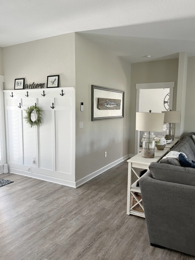 no entryway, hooks on wall with board and batten, gray wash wood floor. Sherwin Williams Agreeable Gray paint color on walls.