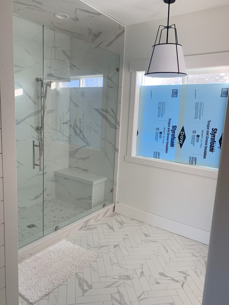 Bathroom with marble look tile and Benjamin Moore Swiss Coffee walls. CLIENT PHOTO of Kylie M Interiors Edesign