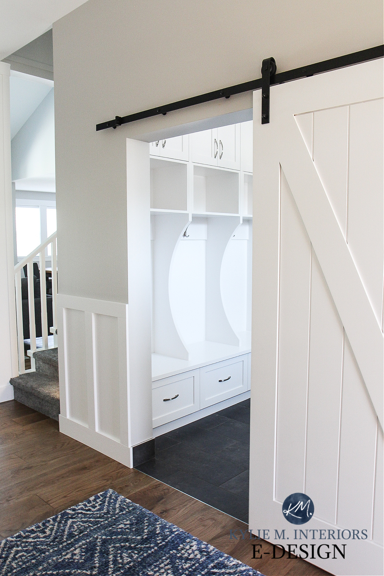 Sliding barn doo into laundry room mud room with built in bench, white wainscoting, Benjamin Moore Stonington Gray and Sherwin High Reflective White. Kylie M Interiors Edesign, diy upate ideas.