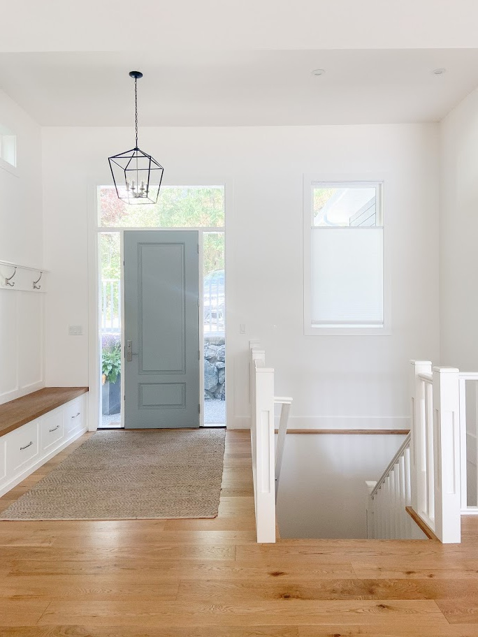 Same white on trim, ceilings, walls, cabinets. Foyer with Benjamin Moore Super White and Sherwin Gris painted front door, white oak flooring. Kylie M Interiors diy decorating ideas and edesign