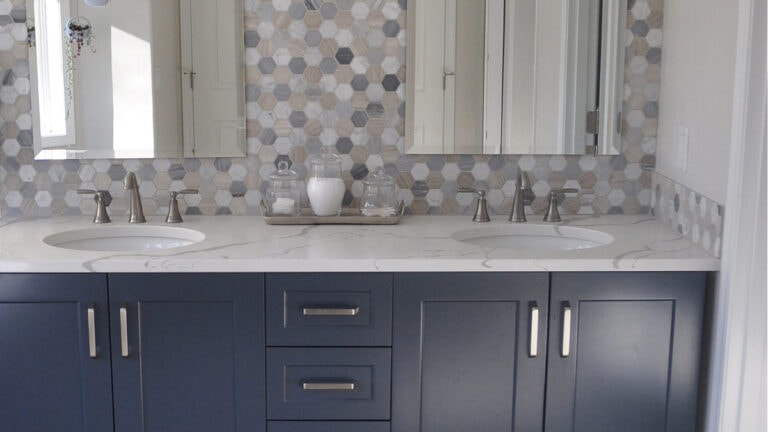 Benjamin Moore Hale Navy looking blue vanity in bathroom with hexagon marble backsplash and white quartz
