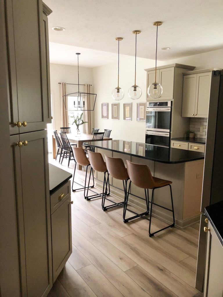 Black granite countertops, painted cabinets, Sherwin Williams Alabaster walls, coganc leather bar stools. Client photo, Kylie M Interiors Edesign