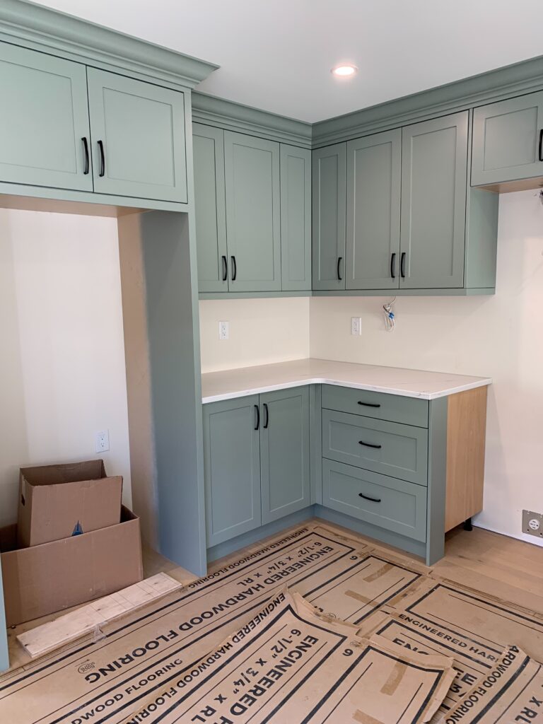 Sherwin Williams Evergreen Fog on kitchen cabinets, white quartz countertops. best green paint colour painted cabinets.