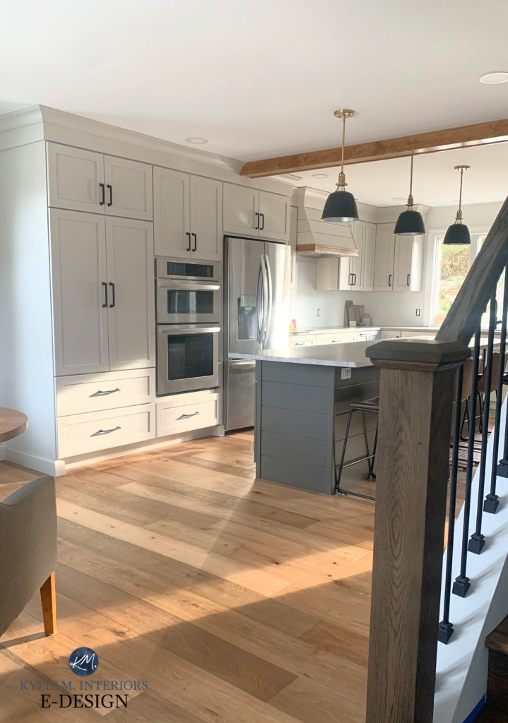 Kitchen with wood flooring, Sherwin Williams Agreeable Gray painted cabinets, URbane Bronze greige island, black pendant lights. Kylie M Interiors Edesign