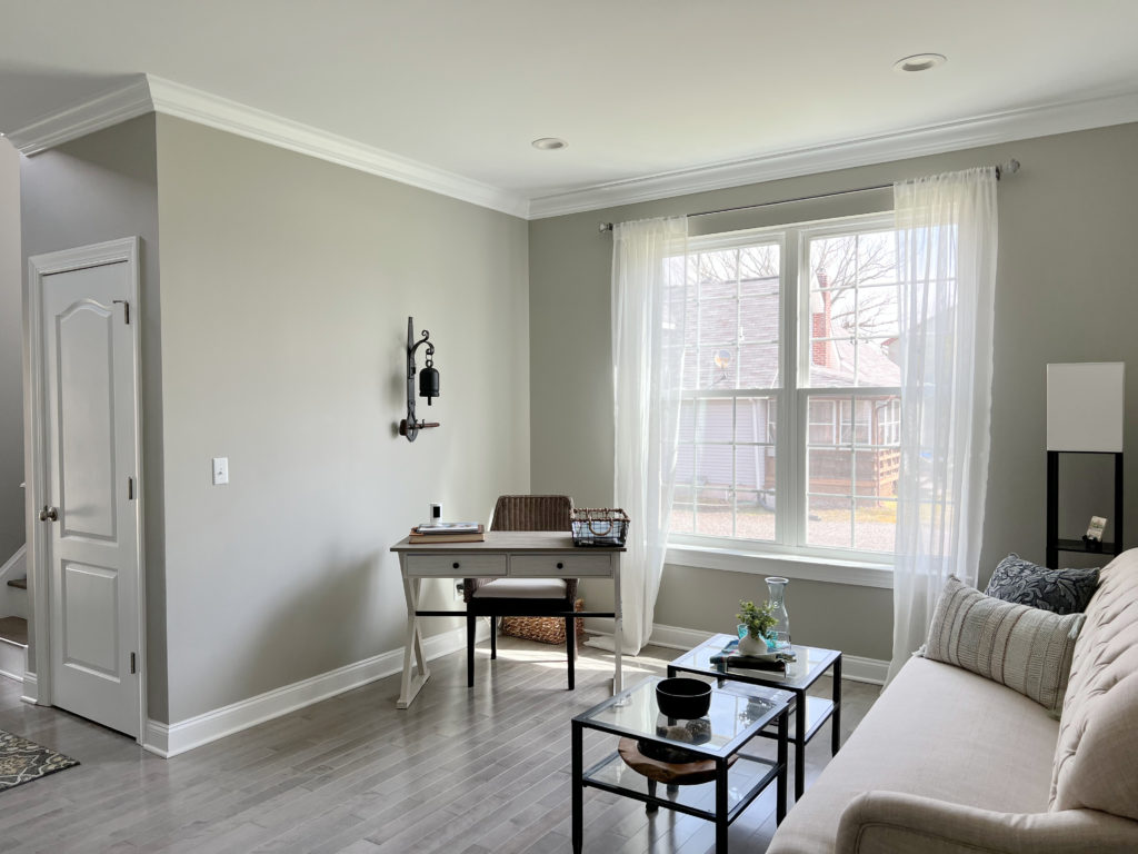 Sherwin Williams Mindful Gray, warm gray paint colour, violet hue gray wood flooring, neutral furnishings.