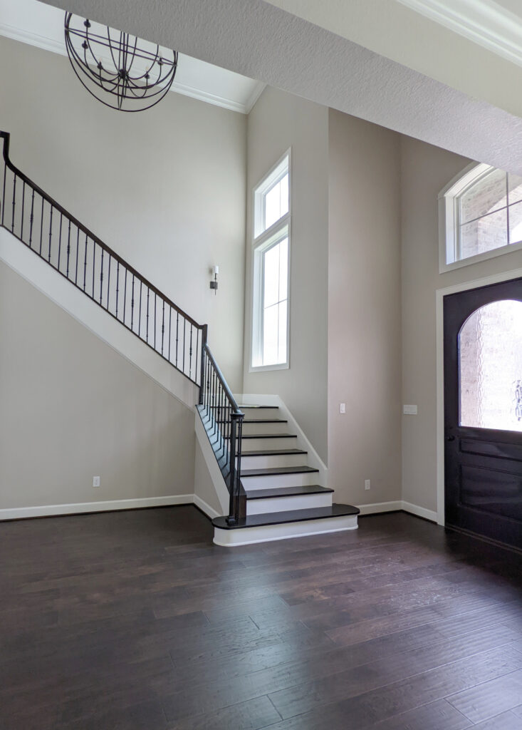 Entryway, staircase, Sherwin Williams Accessible Beige, Benjamin MOore White Dove, dark wood flooring and railing. Kylie M design blog