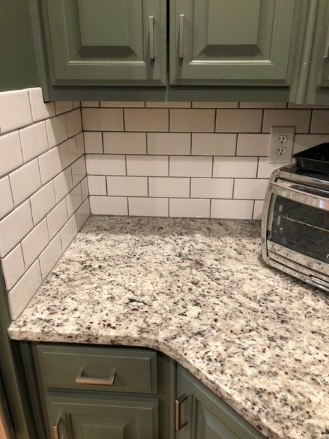 Green painted wood kitchen cabinets, granite countertop, Sherwin Williams Rosemary, white subway tile. Kylie M