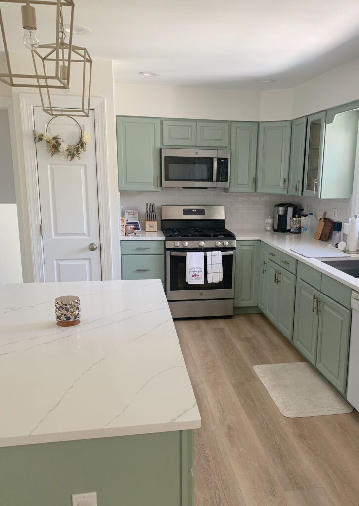 Kitchen cabinets and island painted Sherwin Williams Cascade Green, white quartz countertop, Cloud White walls. Kylie M paint color blogger