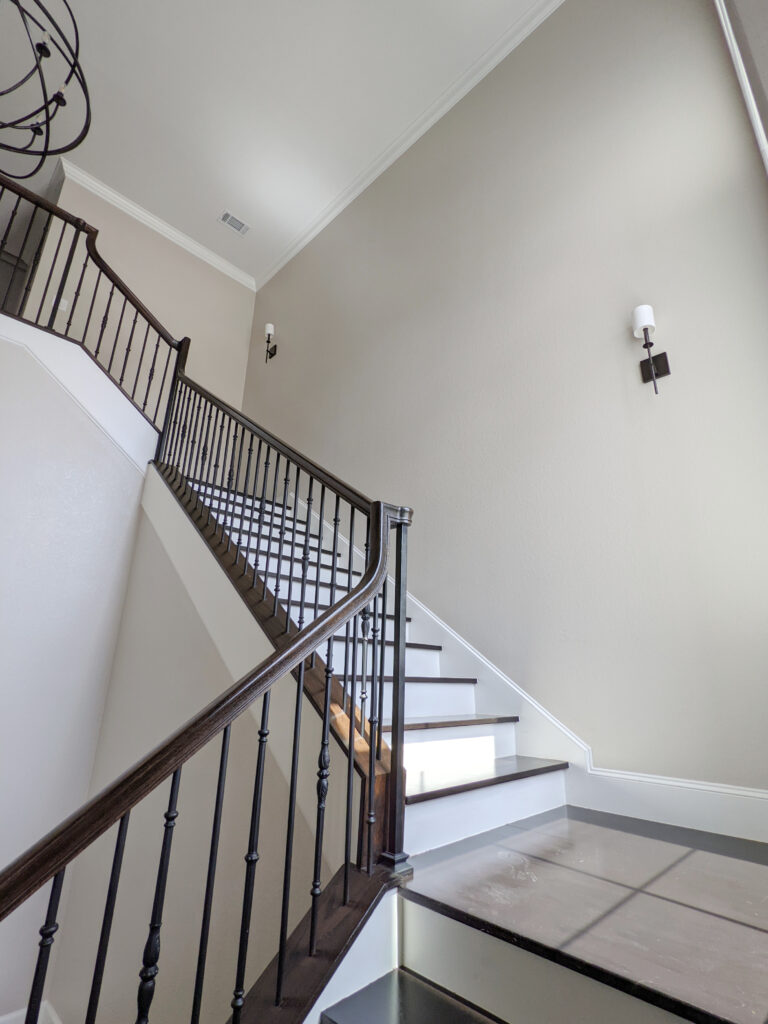 Sherwin Williams best beige paint colour, Accessible Beige, White Dove trim, dark wood flooring, stairs, hand railing, metal spindles, white risers. Kylie M blog