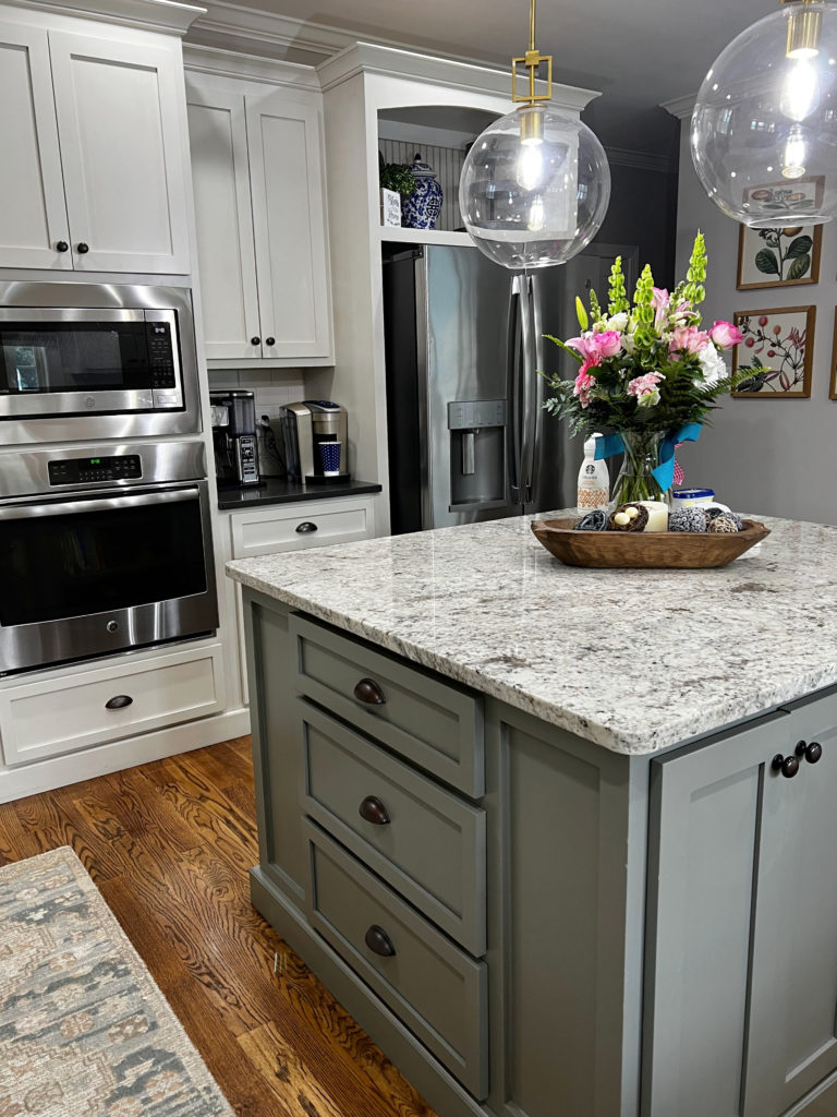 Benjamin Moore Linen White painted kitchen cabinets, cream cabinets, Chelsea Gray painted island, speckled white granite countertop, wood oak flooring