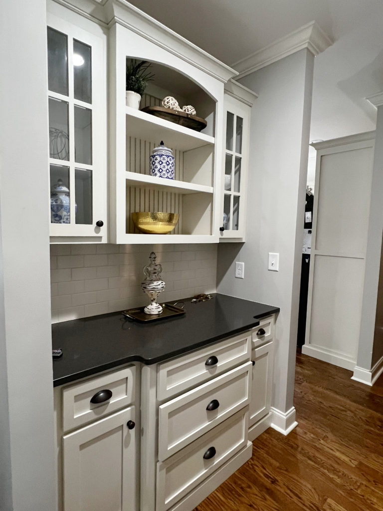 Sherwin Williams Agreeable Gray a greige paint color on walls with cream painted cabinets in Benjamin Moore Linen White, oak wood flooring, butlers pantry