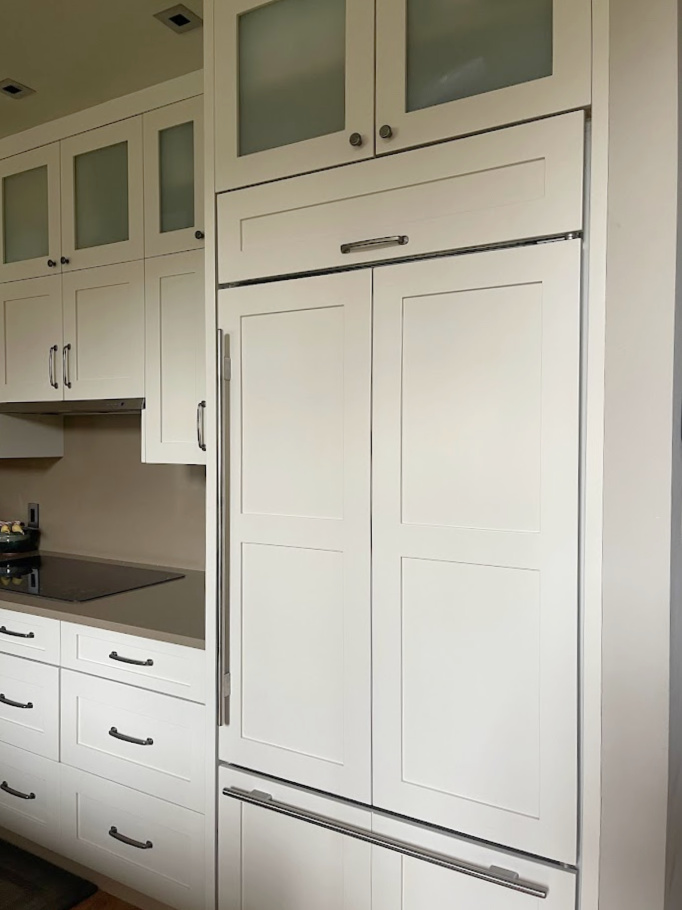 Benjamin Moore Natural Cream warm neutral paint color on painted kitchen cabinets with brown quartz countertops