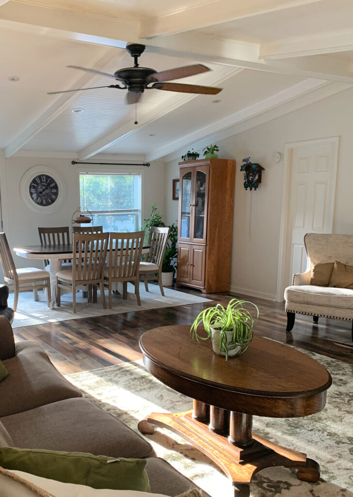 Sherwin WilLiams White Duck in open layout living room and dining room. White tongue and groove painted ceiling with beams. Kylie M Interiors Edesign