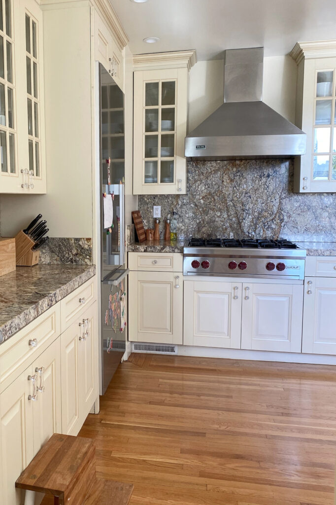 Cream kitchen cabinets, painted with granite countertop, orange warm wood floor. Kylie M Edesign client photo