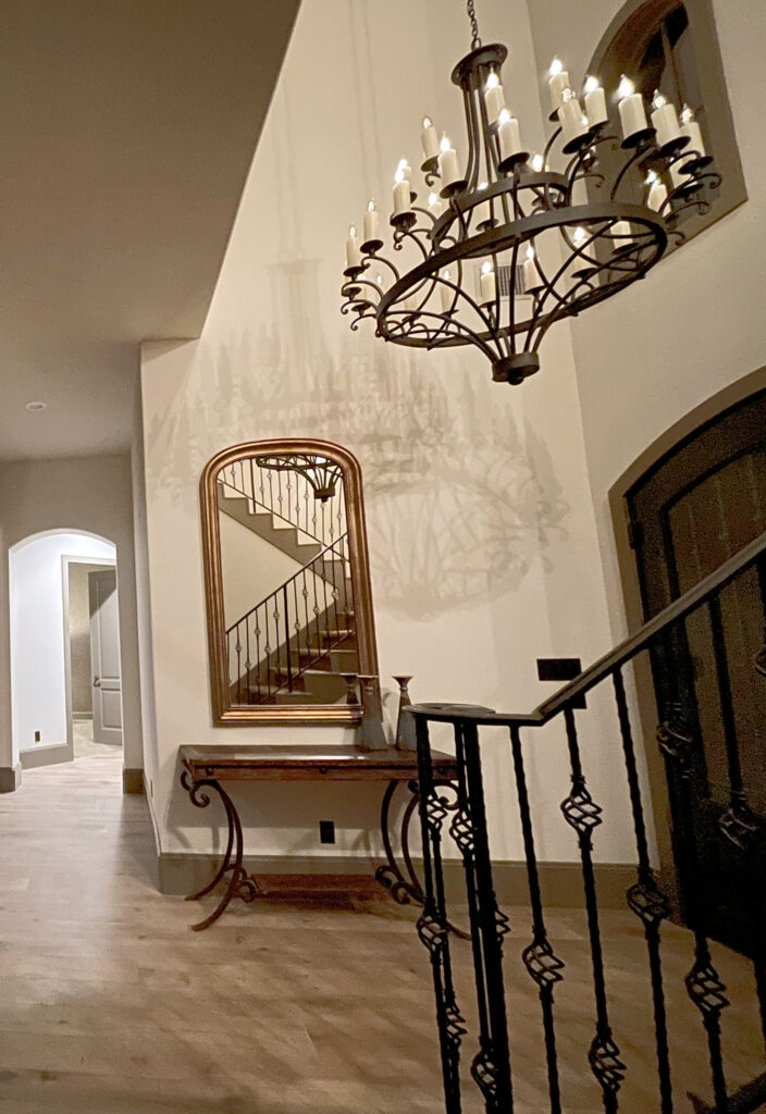 Aesthetic White foyer, Spanish, tuscan style, wrought iron railing and chandelier, Aesthetic White walls, Texas Leather greige trim. Kylie M Edesign