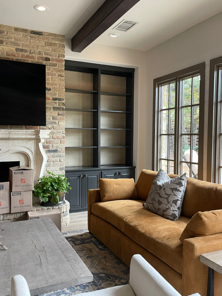 Aesthetic White walls, beige offwhite, Iron Ore on built-ins with grass cloth, Texas Leather warm gray greige trim, wood beams, brick beige fireplace, stone mantel. Kylie M Interiors Edesign
