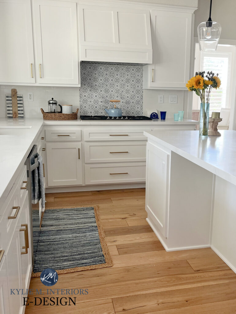 Kitchen with Sherwin Williams Pure White painted cabinets. Best white. wood floor, white quartz marble look countertop, accent tile behind stove. Gold brass hardware. Kylie M Edesign
