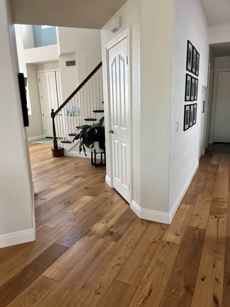 Sherwin Williams Neutral Ground, best tan cream blend. Pure White trim. hallway with wood flooring. Kylie M Online paint color expert