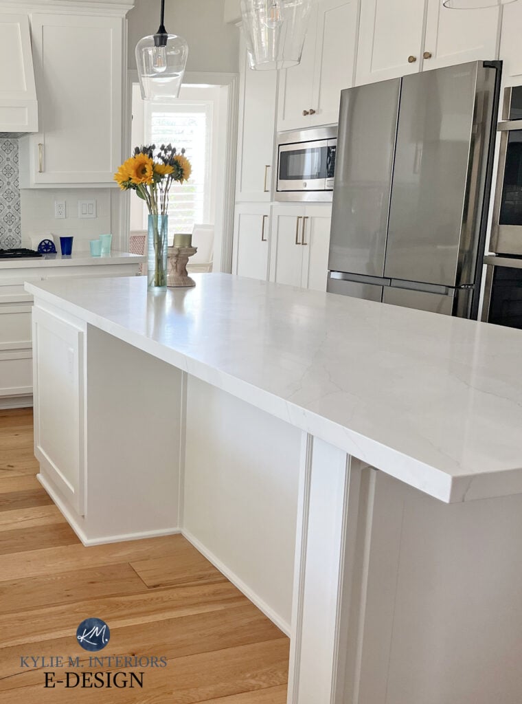 White quartz marble look countertop update. Sherwin Williams Pure White cabinets. wood floor, stainless steel appliances. Kylie M Interiors online paint color expert