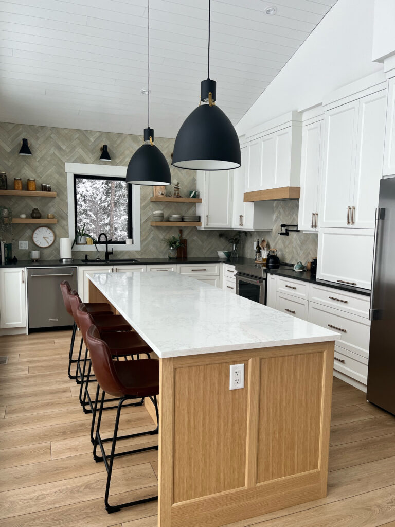 Benjamin Moore Oxford White painted kitchen cabinets, wood oak island, wood floor, black pendants, mountain style chalet home, vaulted tongue and groove ceiling