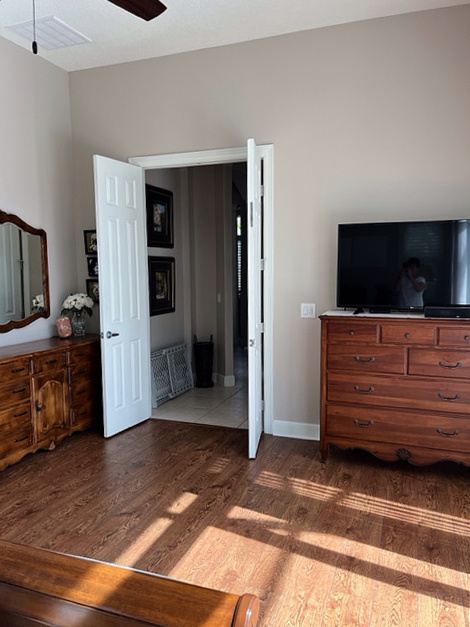 Red oak stain flooring, red bedroom furniture, Benjamin Moore Cedar Key beige taupe paint color. Kylie M Edesign