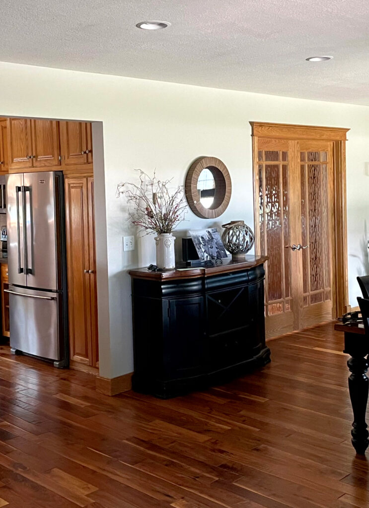 Sherwin Williams Accessible Beige with wood trim, wood floor, wood doors and home decor. Undertones showing green. Kylie M ONline Paint Color Consulting