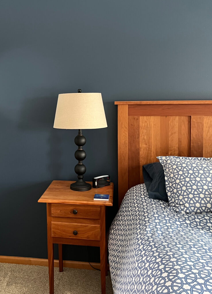 South facing room, Benjamin Moore Newburyport Blue, orange stained wood trim and bedroom furniture. Beige carpet. Kylie M Interiors Edesign