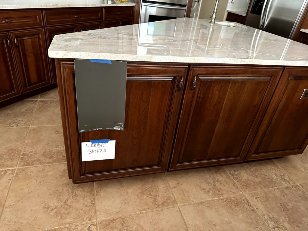 sherwin Williams Urbane Bronze on cherry red stained wood island, quartzite countertop with beige floor tile looks like travertine. Kylie M Online paint color consulting