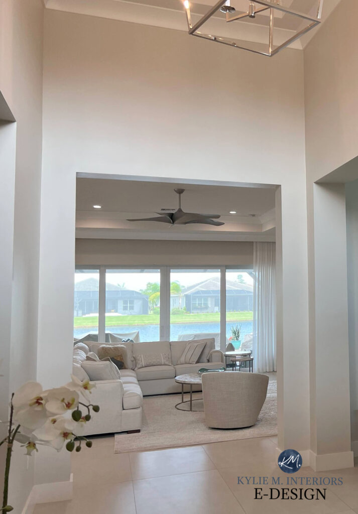 Open concept entryway and living room, beige tile floor, cream furniture, Sherwin Williams Aesthetic White off-white beige paint color on walls. Travertine look. Kylie M Interiors