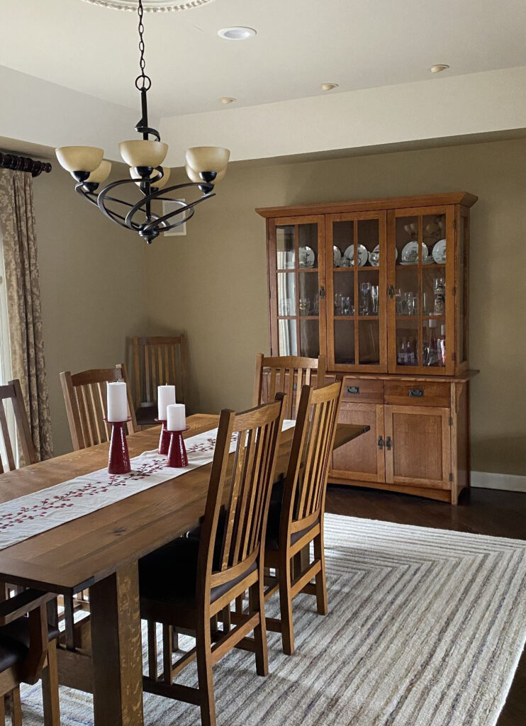 Benjamin Moore Great Plains, medium beige tan paint color, tray ceiling, high, traditional oak dining set and buffet hutch, wood floor dark. Kylie M