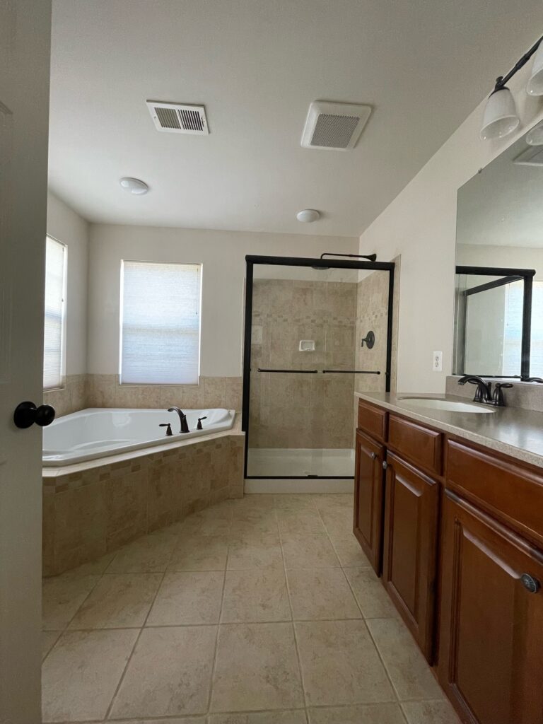 2000s beige tuscan style bathroom, beige tile, wood vanity, soaker tub, walk in shower