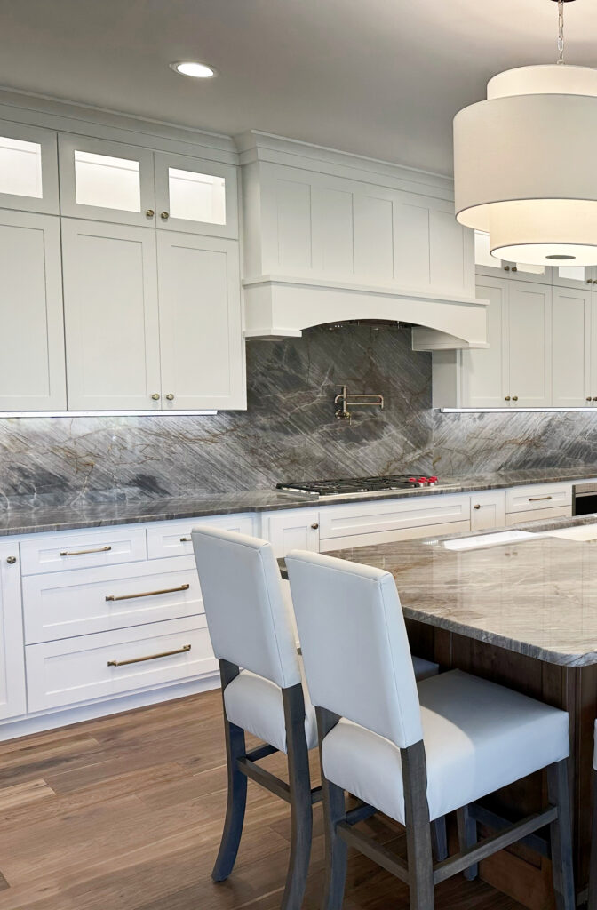 Kitchen island quartzite, gray quartz brown veins, pendant lights, Sherwin Williams Pure White cabinets, brass hardware, wood island, stools. Kylie M Online color consultant (1)