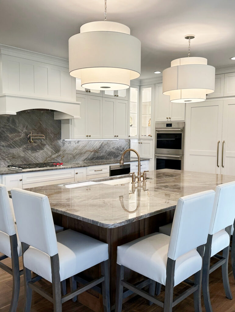 Kitchen island quartzite, gray quartz brown veins, pendant lights, Sherwin Williams Pure White cabinets, brass hardware, wood island, stools. Kylie M Online color consultant (2)